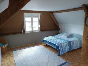 a bedroom with a bed and a window at Maison De Vacances in Dancourt
