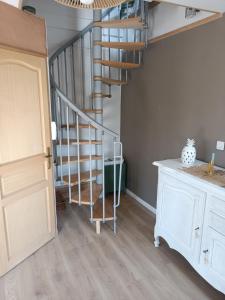 a hallway with a spiral staircase in a house at Maison De Vacances 