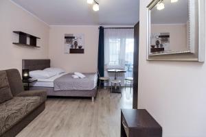 a bedroom with a bed and a couch and a mirror at CLIFF House in Międzyzdroje +9 photos