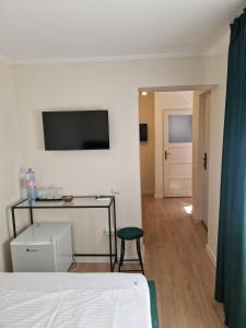 a bedroom with a bed and a table and a chair at Vila Andora in Eforie Nord