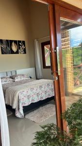 a bedroom with a bed and a sliding glass door at Belaninha in Guaramiranga