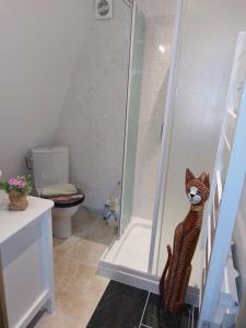 a bathroom with a shower with a cat statue next to it at TIPI d'ANAÏS in Sarlande