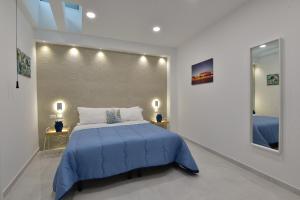 a bedroom with a blue bed and a mirror at Appartamento Ortigia Vicolo Lettighieri 22 in Siracusa