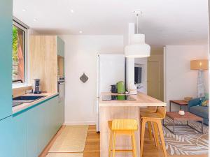 a kitchen with a kitchen island with two yellow bar stools at Le Lodge SXM luxe in Cul de Sac
