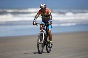 a man riding a bike on the beach at Casa Com Piscina Completa Ilha Comprida in Ilha Comprida