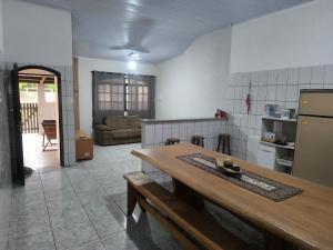 a kitchen with a table and a refrigerator and a couch at Casa Com Piscina Completa Ilha Comprida in Ilha Comprida