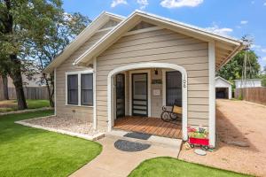 une petite maison avec une porte ouverte avec un porche dans l'établissement Deannie's Cottage, à Fredericksburg