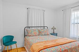 une chambre avec un lit et une chaise bleue dans l'établissement Deannie's Cottage, à Fredericksburg