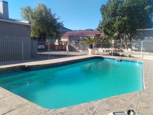 a swimming pool in front of a fence at The Cottage in De Rust