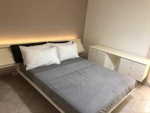a bedroom with a bed with two pillows and a desk at Dimora CentoDue in Bari