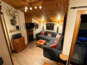 La Plagne TarentaiseLe Chalet De Montchavin - Bel appartement duplex proche du centre MAE-4254的客厅里有一张沙发和一张桌子。