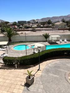 a swimming pool with a table and chairs next to it at Departamentos Innova in Copiapó