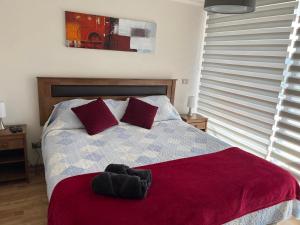 a bedroom with a bed with a red blanket at Departamentos Innova in Copiapó +19 photos