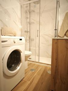 y baño con ducha y lavadora. en Charmoso T1 Varandas de Malpique, en Albufeira
