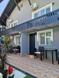 a house with a patio with a table and a balcony at Vila Andora in Eforie Nord