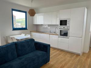 a living room with a couch and a kitchen at Blue Shark Appartment in Horta