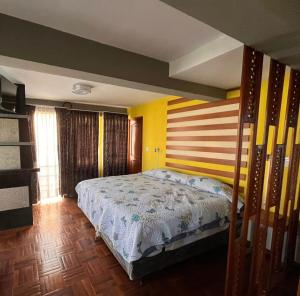 - une chambre avec un lit et un mur rayé dans l'établissement Casa Corp 9, à Sucre