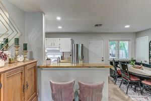 a kitchen with a counter and chairs and a table at Dulwich Drift - Cowboy Pool Fire Pit & Chill Backyard Vibes in Austin