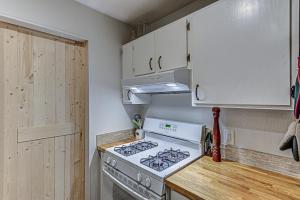 a kitchen with a stove and white cabinets at Dulwich Drift - Cowboy Pool Fire Pit & Chill Backyard Vibes in Austin