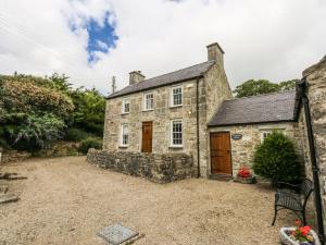 an old stone house with a large yard at Tyddyn Iolyn in Benllech