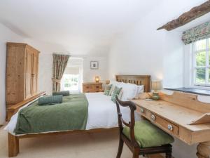 a bedroom with a large bed and a wooden desk at Tyddyn Iolyn in Benllech