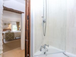 a bathroom with a shower and a tub with a sink at Tyddyn Iolyn in Benllech +45 photos