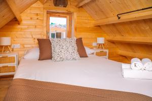 アジャリスにあるCabañas de Allariz - Cabaña 5のログキャビン内のベッド1台(ランプ2つ付)