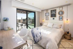 Un dormitorio con una cama y una mesa y un balcón. en Villa Avalon - Bedzy Luxury, en Almancil 47 fotos más