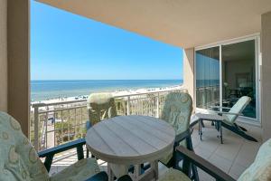 un tavolo e sedie su un balcone con vista sulla spiaggia di Indigo East Unit 403W a Pensacola
