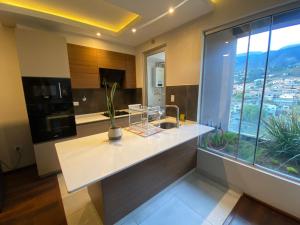 a kitchen with a white counter and a window at Garden Suite in Cochabamba