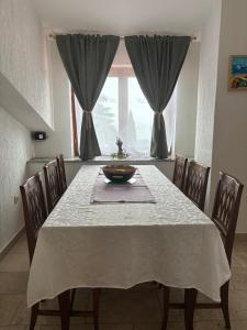 a dining room with a table with chairs and a window at Apartments Kristic in Lovran