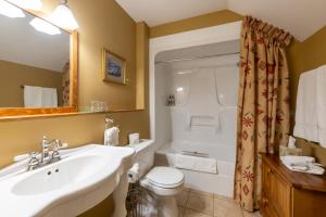 a bathroom with a sink and a toilet and a tub at Vagabond Lodge at Kicking Horse in Golden +38 photos