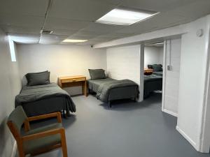 a room with two beds and a table and a chair at Best Deal-8 beds- Perfect for large Team in Willmar