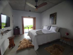 a bedroom with a bed and a television and a rug at VisttaSC in Praia Grande