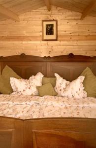 a bed in a room with a wooden wall at AlmOtel - Auf der HerziAlm 