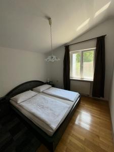 a bedroom with a bed and a window at Apartments Kristic in Lovran