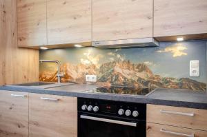 a kitchen with a mountain mural on the wall at Bio-Bauernhof Bachangerhof in Kössen