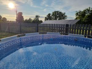 a swimming pool in a backyard with a fence at W Małym Sadzie in Dobra