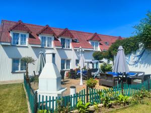 a building with a fence and an umbrella at Błękitna Fala in Ustka