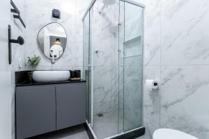 a bathroom with a shower with a sink and a mirror at Studio Completo: Metrô e Aterro do Flamengo in Rio de Janeiro