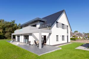 a white house with a black roof at Ferienwohnung Justus in Karlshagen