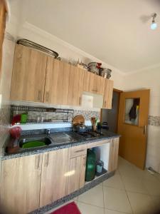 a kitchen with wooden cabinets and a sink at شقة جاردينيا - طنجة البالية in Tangier