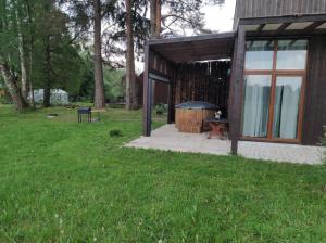 a cabin with a grill in a grass field at Baltic Box in Lielvārde