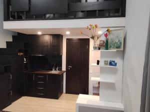 a kitchen with black cabinets and a sink at Baltic Box in Lielvārde
