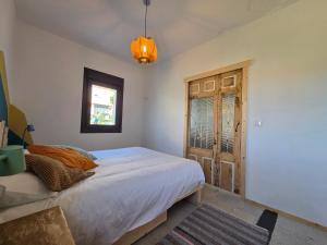 Schlafzimmer mit einem Bett und einer Holztür in der Unterkunft A Casa De Margó, casa con encanto en O Grove in San Vicente do Mar