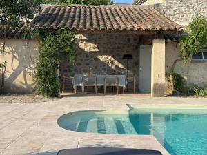 a house with a table and a swimming pool at Maison Casamande & SPA - Luxe et sérénité dans un domaine d'amandiers in Bouquet