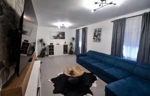 a living room with a blue couch and a table at Apartman Kristina in Lovran