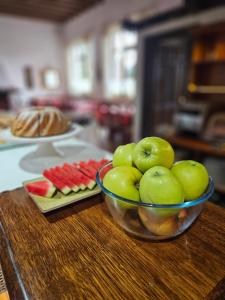 a bowl of apples on a table with a plate of fruit at Penzión Encián in Tatranská Lomnica