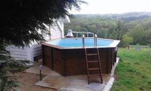 a hot tub with a ladder next to a house at TIPI d'ANAÏS in Sarlande