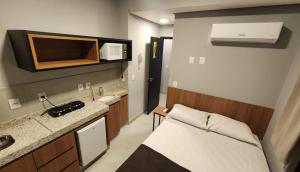 a small room with a bed and a sink at FLATS CERRADO santa casa in Montes Claros